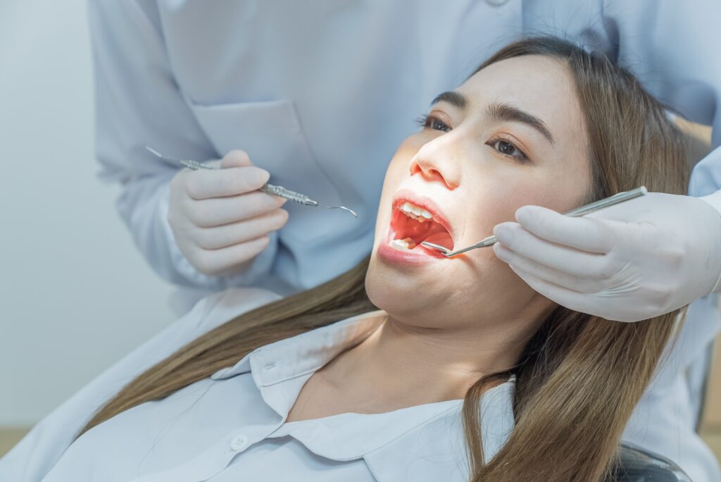 Dentist performing a dental filling procedure in Greenwood using medical instruments.